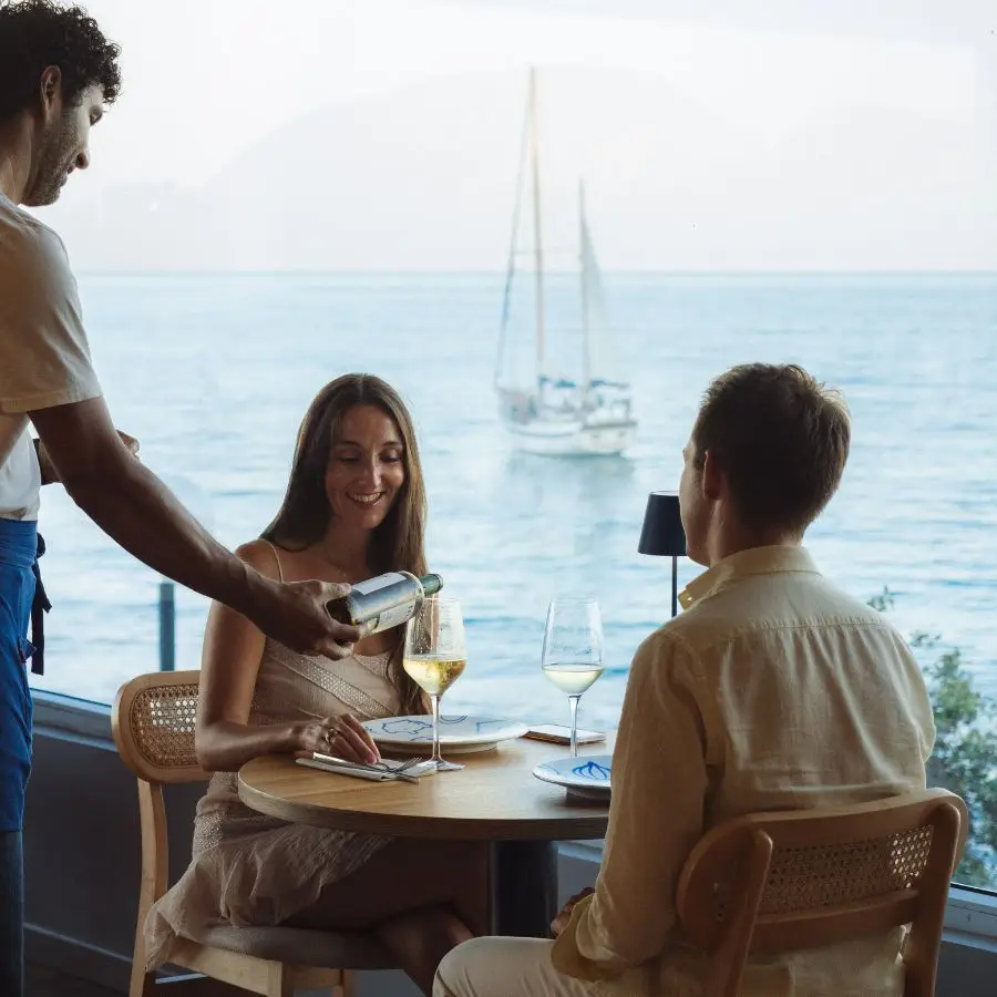 Dos comensales disfrutando de una comida en COR con vistas al mar de fondo